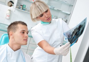 Eine Zahnärztin erklärt dem Patienten den Eingriff